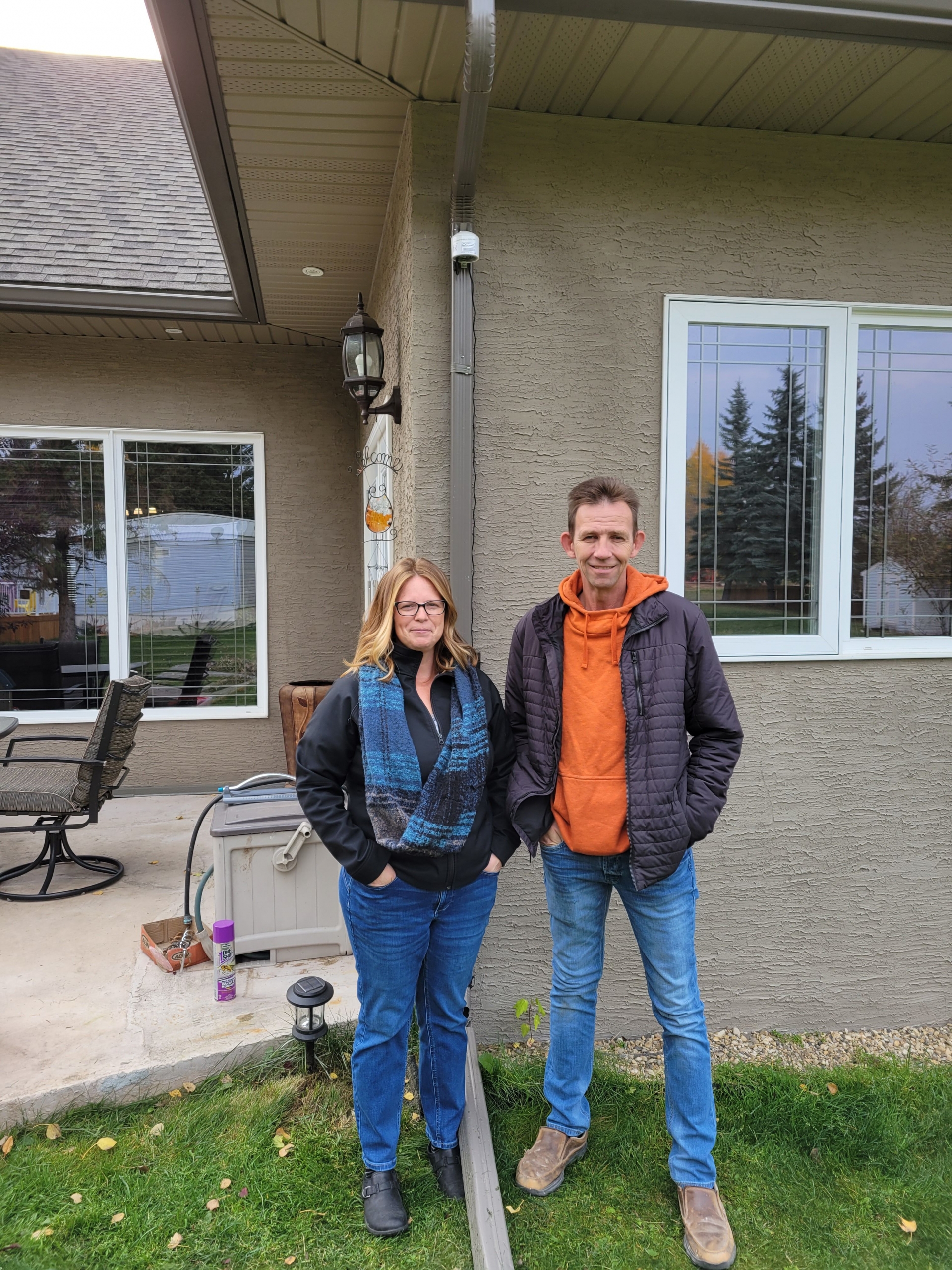 Tammy and Dennis Wade pose under their newly installed Purple Air Sensor at their home.